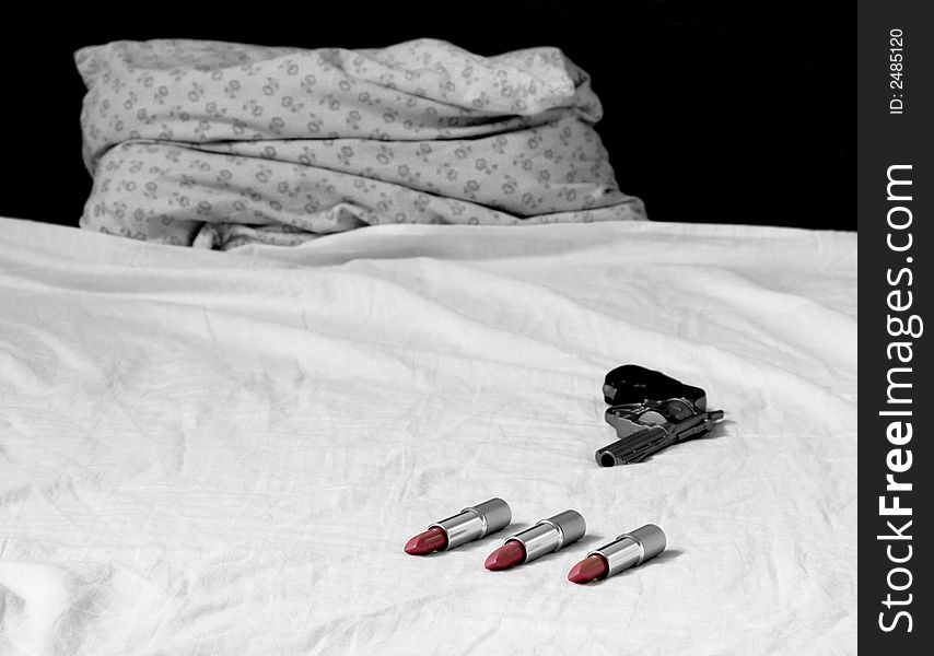 Red lipsticks in the bed with gun. Red lipsticks in the bed with gun