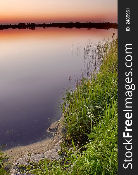 A calm lake after sunset. A calm lake after sunset