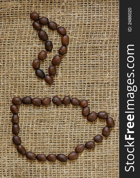 Contour of coffee cup made from coffee grains over burlap background