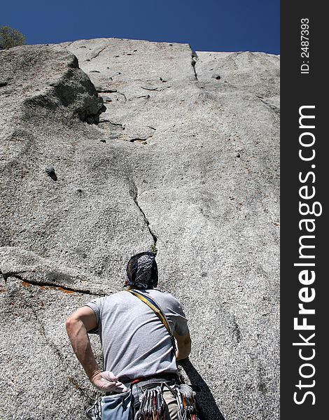 A man getting started on a rock climb. A man getting started on a rock climb