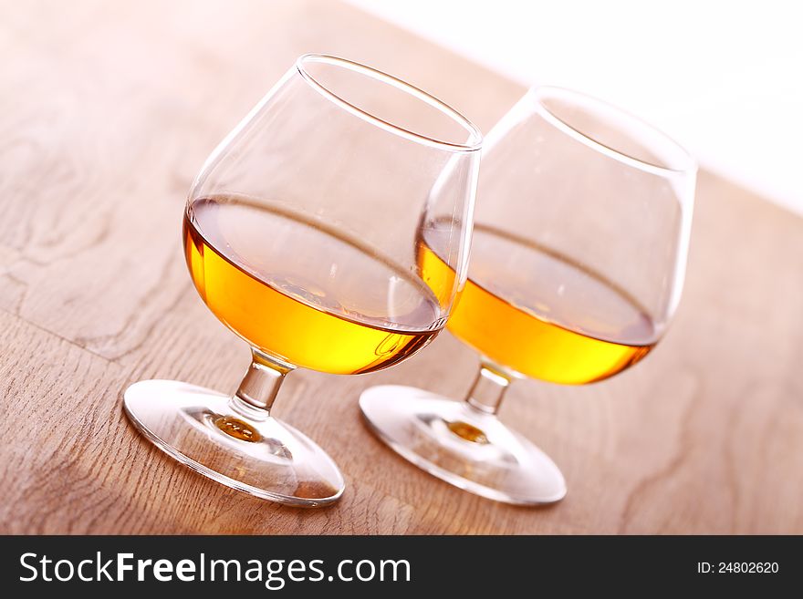 Glass of cognac over wooden surface