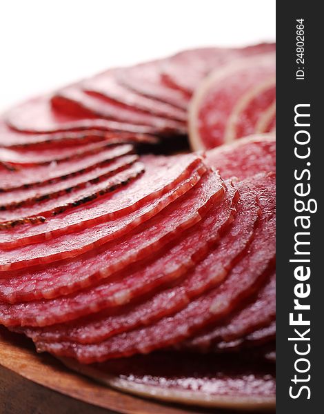 Slices of fresh and delicious salami over white background