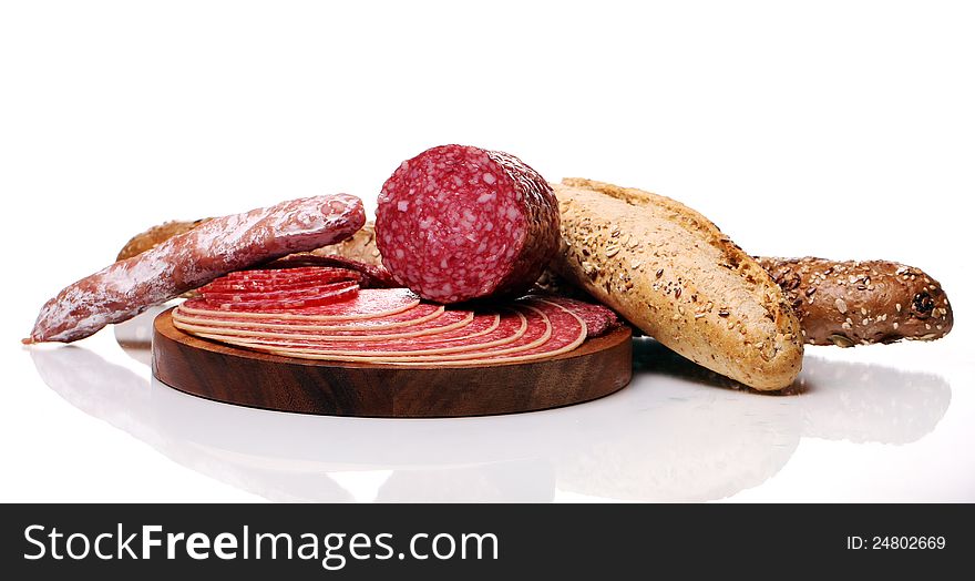 Salami and bread over white background