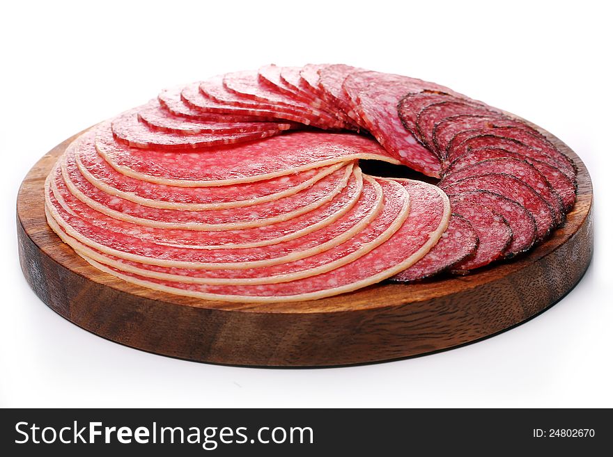 Slices of fresh and delicious salami over white background