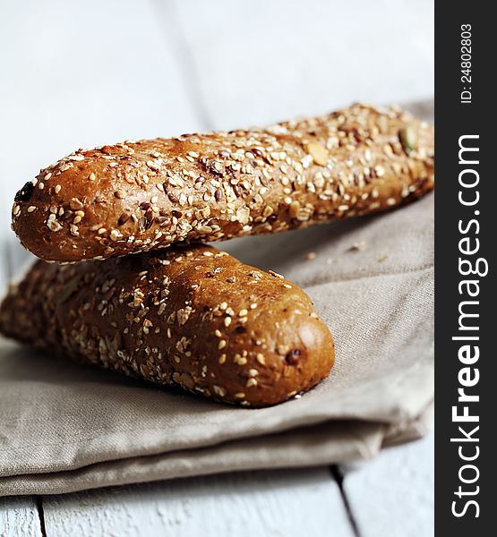 Tasty buns with different seeds on the wooden table