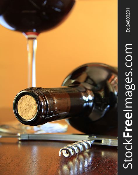 Close up of a red wine bottle with steel corkscrew. Close up of a red wine bottle with steel corkscrew