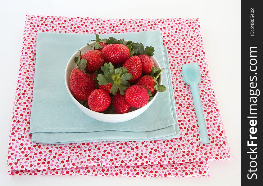 Strawberries in a bowl with napkin and spoon