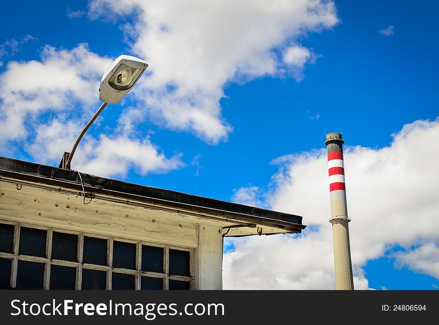 Power plant chimney  with red and white stripes, industrial building and lamp. Power plant chimney  with red and white stripes, industrial building and lamp.