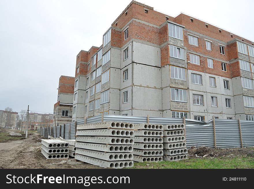 The angle of the unfinished building, surrounded by a fence. The angle of the unfinished building, surrounded by a fence