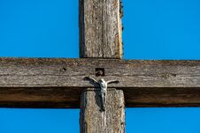 An Old Wooden Cross Against A Clear Blue Sky. The Crucified Jesus On The Cross. The Concept Of The Pure And Unrequited Love Of God Stock Images
