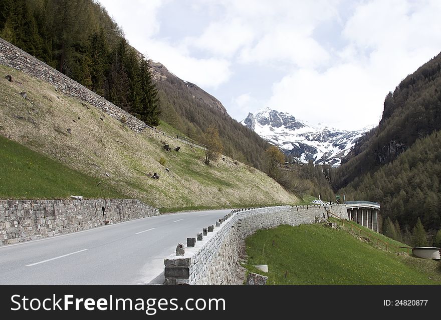Road in the alps mountains with stone protection wall and a viaduct away. Road in the alps mountains with stone protection wall and a viaduct away