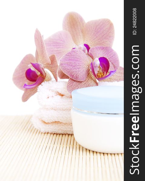 Cosmetic moisturizing cream with pink orchids and towel. Cosmetic moisturizing cream with pink orchids and towel