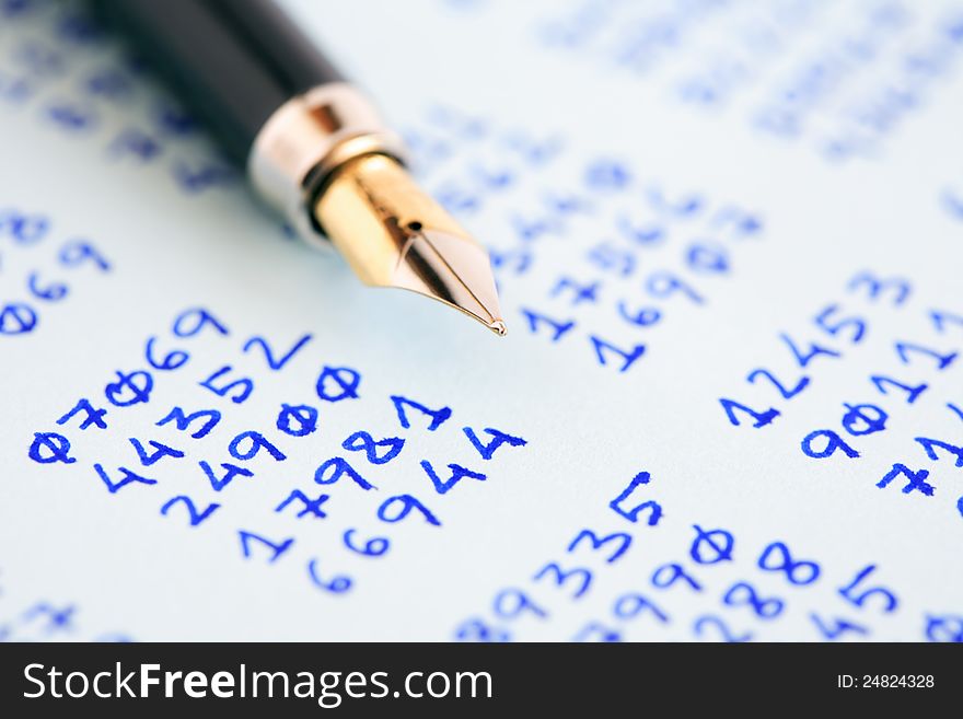 Closeup of fountain pen on paper with columns of written numbers. Closeup of fountain pen on paper with columns of written numbers