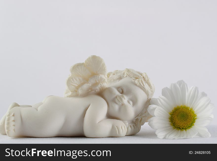 Sleeping angel with white flower on white background