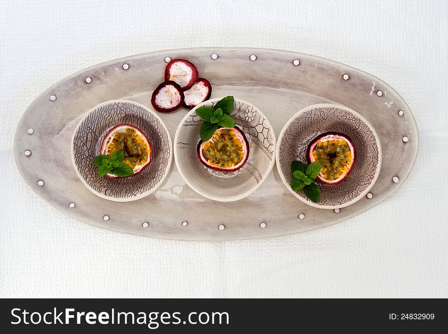 Bowls of Granadilla sliced with mint and isolated on white