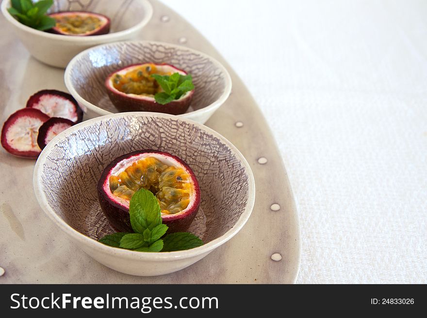 Granedilla fruits with mint on a plate. Granedilla fruits with mint on a plate