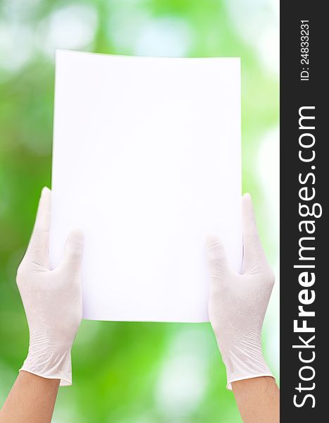 White paper in aseptic hand and green background