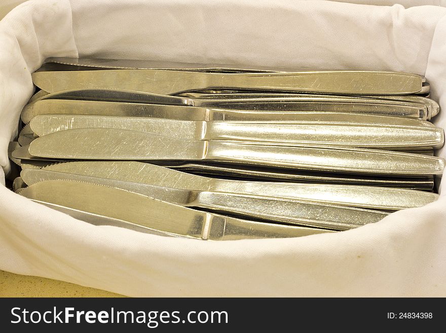 Pile of knifes on white cloth