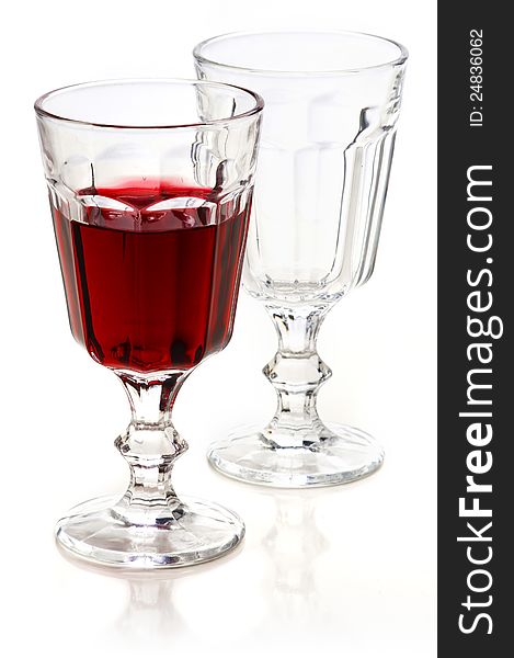 Glass of red wine and empty glass with reflection on a white background. Glass of red wine and empty glass with reflection on a white background.