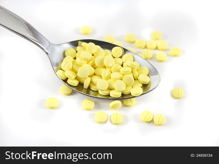 Many pills on spoon with white background