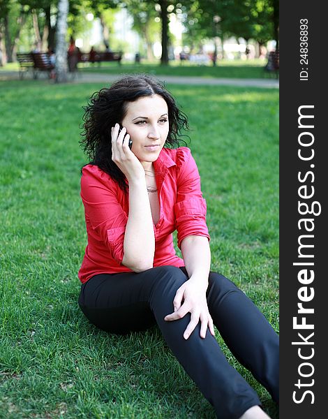 Pretty girl on the phone in the park summer