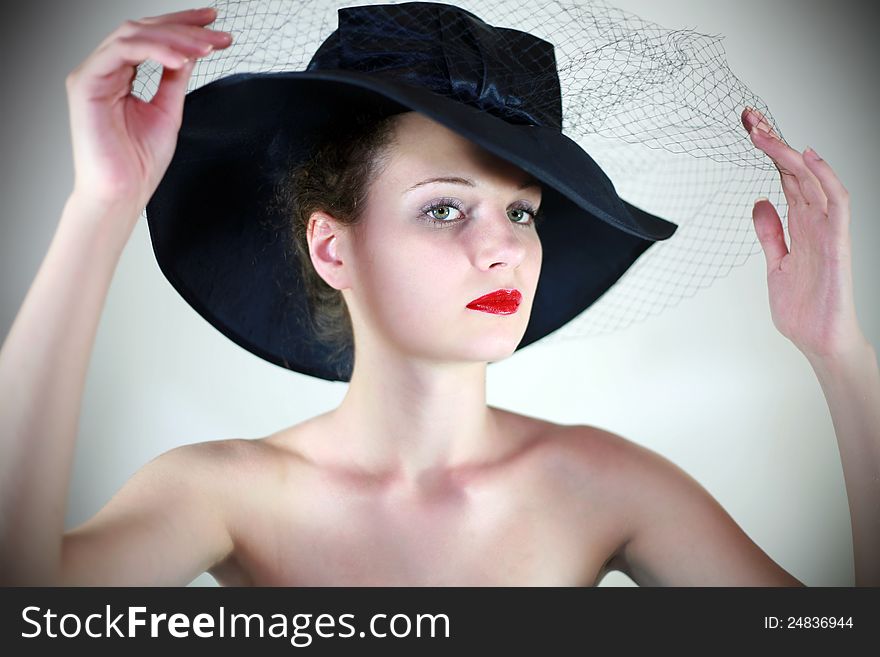 Portrait of a cute girl in a hat with red lips