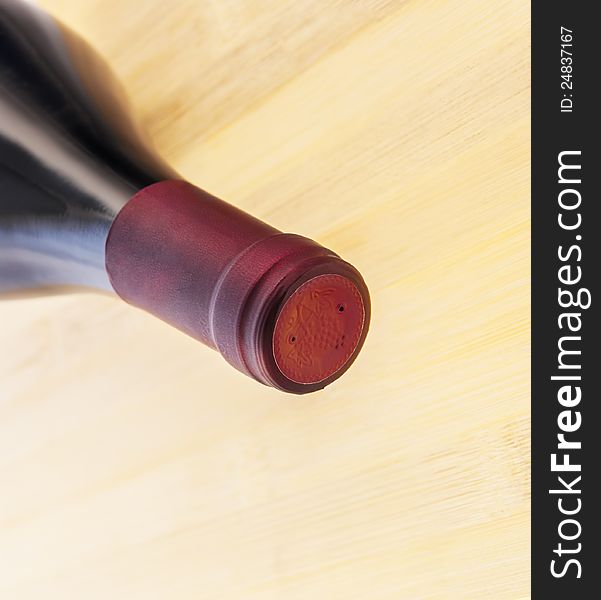 Red wine bottle on wooden table background