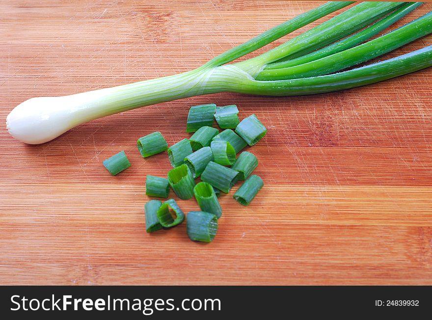 Fresh green onion on wooden board