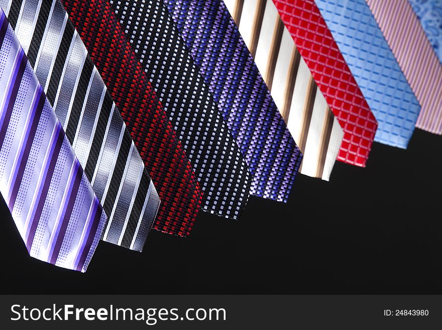Group of colorful ties on the black background