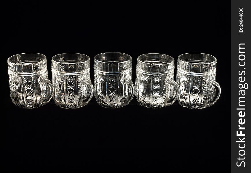 Five empty beer glasses on a black background