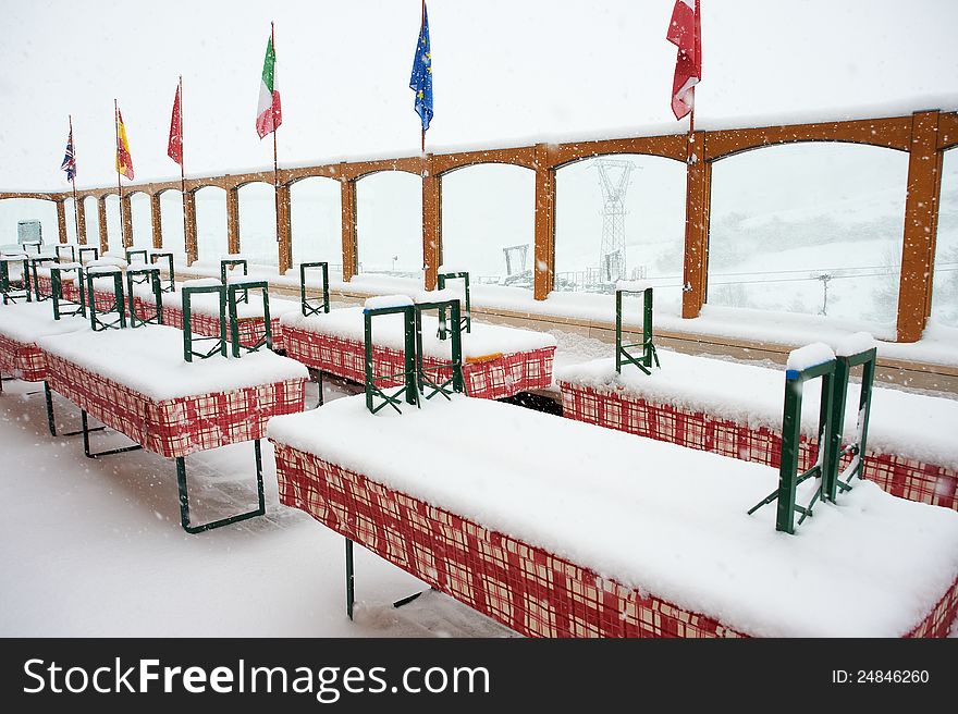 Closed outdoor cafe in the snowfall. Closed outdoor cafe in the snowfall