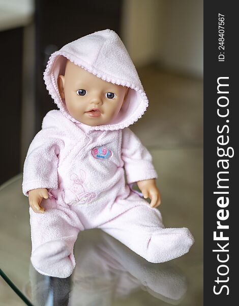 St. Petersburg, Russia - 20.08.2021: a toy for a girl doll little baby born in a pink jumpsuit with a hood
