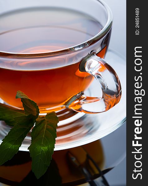 Cup of tea with mint leaf on a saucer