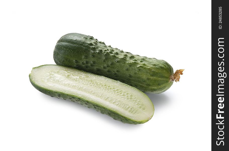 Whole and cut fresh cucumbers on the white background