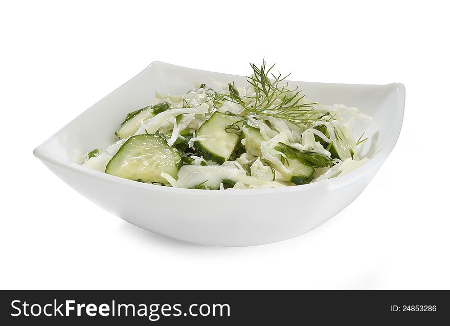 Salad with cabbage and cucumber in the white bowl. Salad with cabbage and cucumber in the white bowl