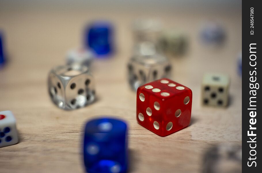 several color dice on a table focus on a red one