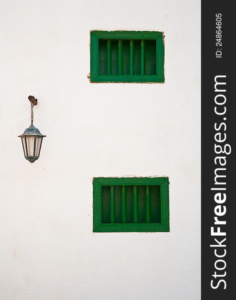 Green windows and light on white wall. Typical Lanzarote island architecture (Canary Islands). Green windows and light on white wall. Typical Lanzarote island architecture (Canary Islands).