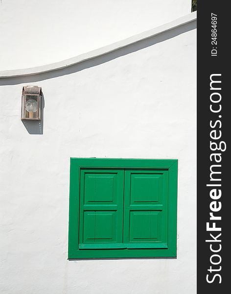 Lantern and green window on a white wall. Typical Lanzarote island architecture. Lantern and green window on a white wall. Typical Lanzarote island architecture.