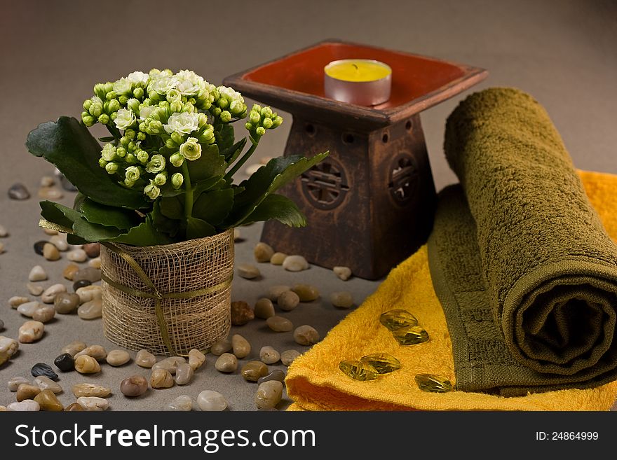 Tranquil spa scene with towels, candle, flower and decoration