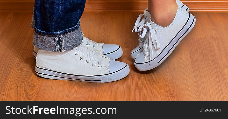 Man and woman in the same sneakers are opposite each other. Man and woman in the same sneakers are opposite each other
