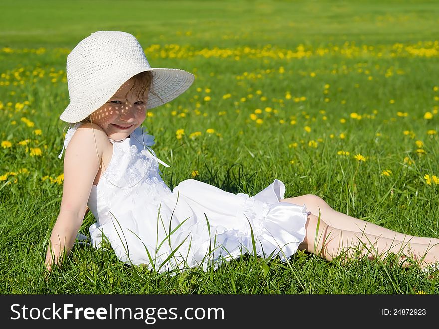 Happy Little Girl Lying On Grass
