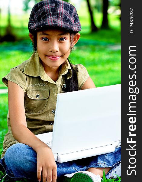 Cute girl sitting in the park with laptop. Cute girl sitting in the park with laptop