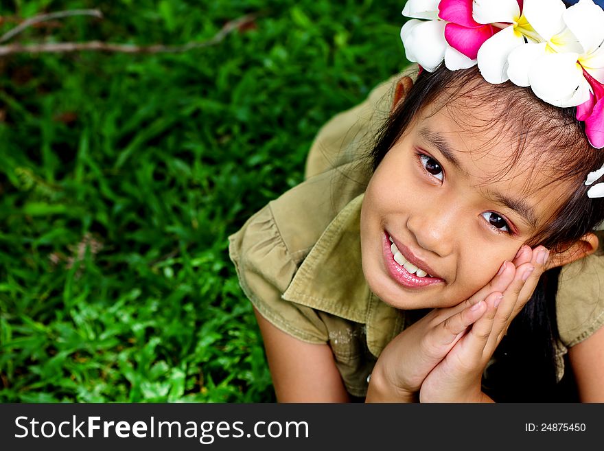 Cute girl flowers on the head with a bright smile. Cute girl flowers on the head with a bright smile