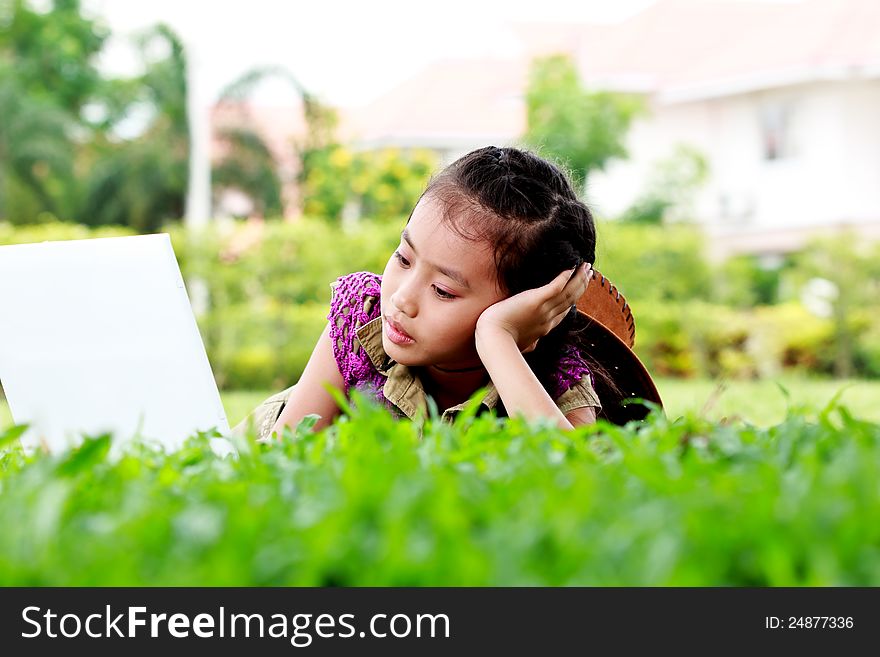 Cute of little girl play laptop in the park