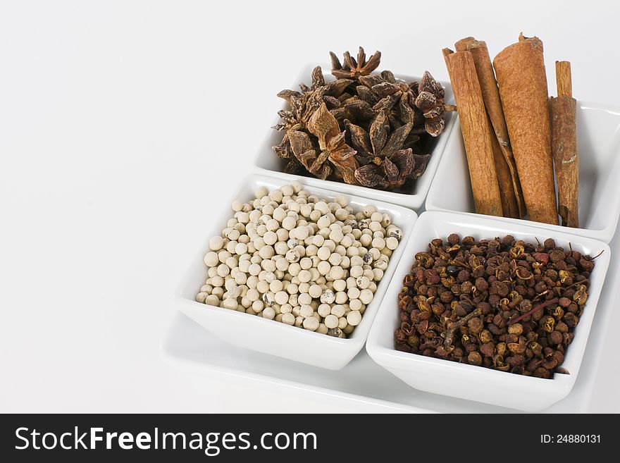 Star Anise, Cinnamon, White Pepper and Coriander Seed in Ceramic Bowl on White Background. Star Anise, Cinnamon, White Pepper and Coriander Seed in Ceramic Bowl on White Background