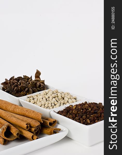 Star Anise, Cinnamon, White Pepper and Coriander Seed in Ceramic Bowl on White Background. Star Anise, Cinnamon, White Pepper and Coriander Seed in Ceramic Bowl on White Background