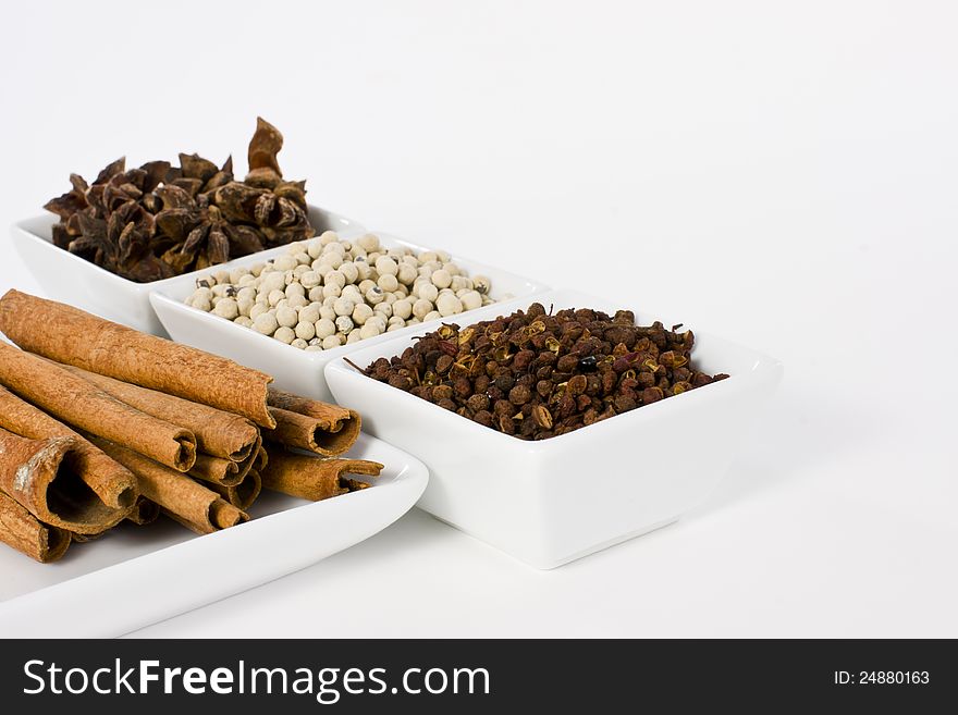 Star Anise, Cinnamon, White Pepper and Coriander Seed in Ceramic Bowl on White Background. Star Anise, Cinnamon, White Pepper and Coriander Seed in Ceramic Bowl on White Background
