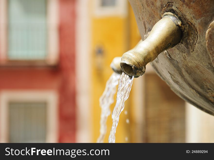 Water pouring from a fountain in the main square of Cuenca, Spain. Shallow depth of field. Water pouring from a fountain in the main square of Cuenca, Spain. Shallow depth of field.