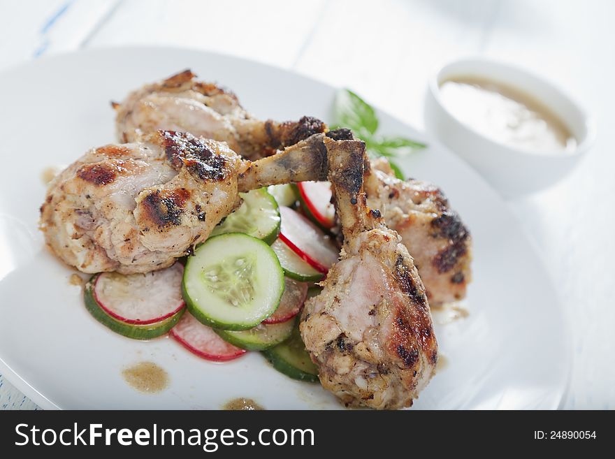 Ginger and lemon chicken drumsticks on a cucumber and radish salad. Ginger and lemon chicken drumsticks on a cucumber and radish salad