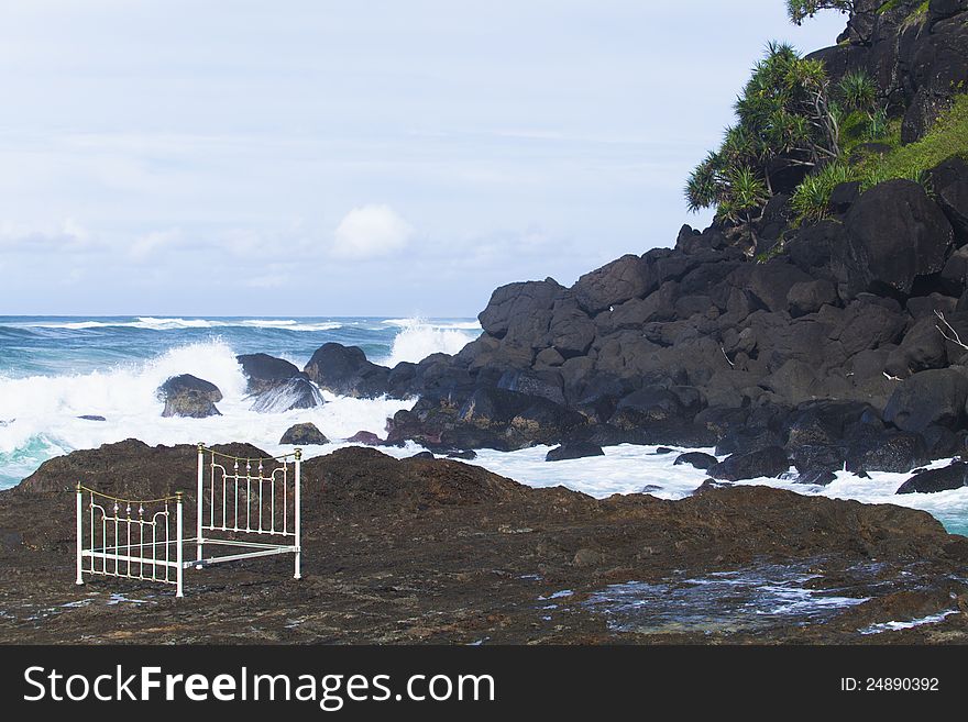 Iron bed frame on beach rocks. Iron bed frame on beach rocks